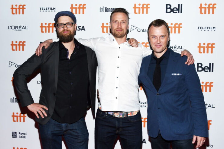 Kiah Roache-Turner, Tristan Roache-Turner and a third man standing on a red carpet