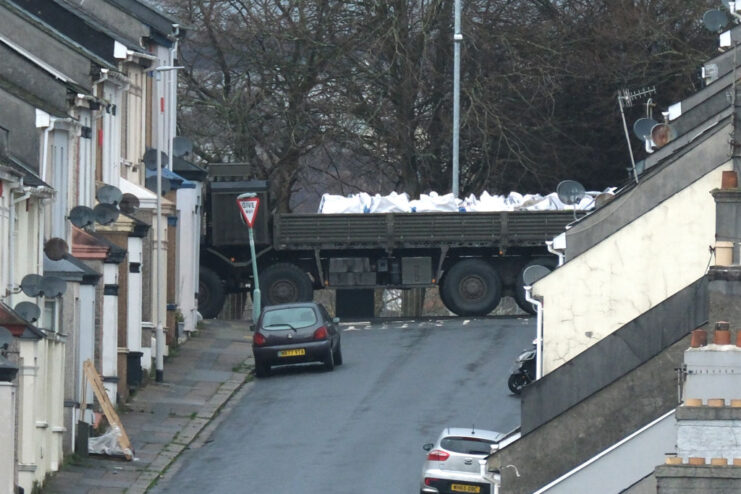 Military vehicle driving through an intersection in a residential neighborhood