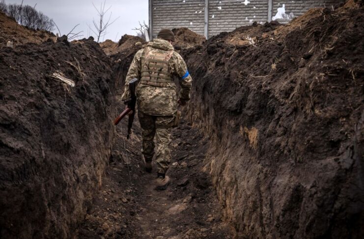 Ukrainian soldier walking through a trench