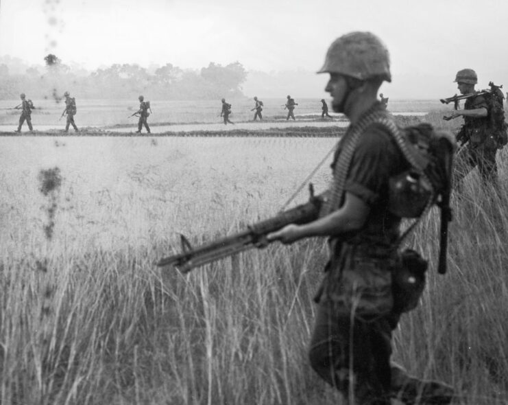 US Marines walking through a rice paddy