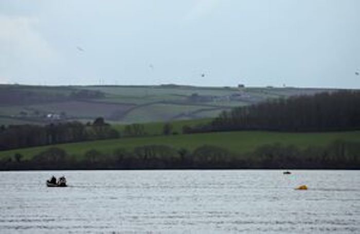 British Royal Navy Bomb Disposal team members riding in a small boat off the coast of Plymouth