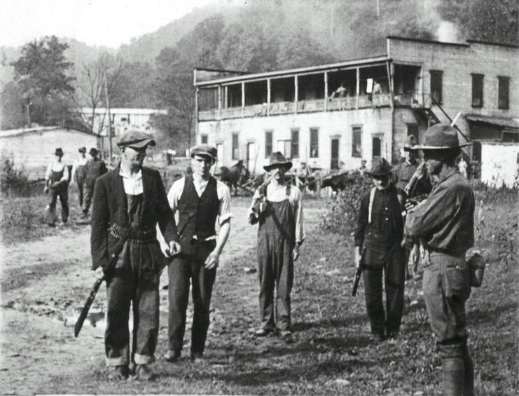 Miners standing with federal troops near a building