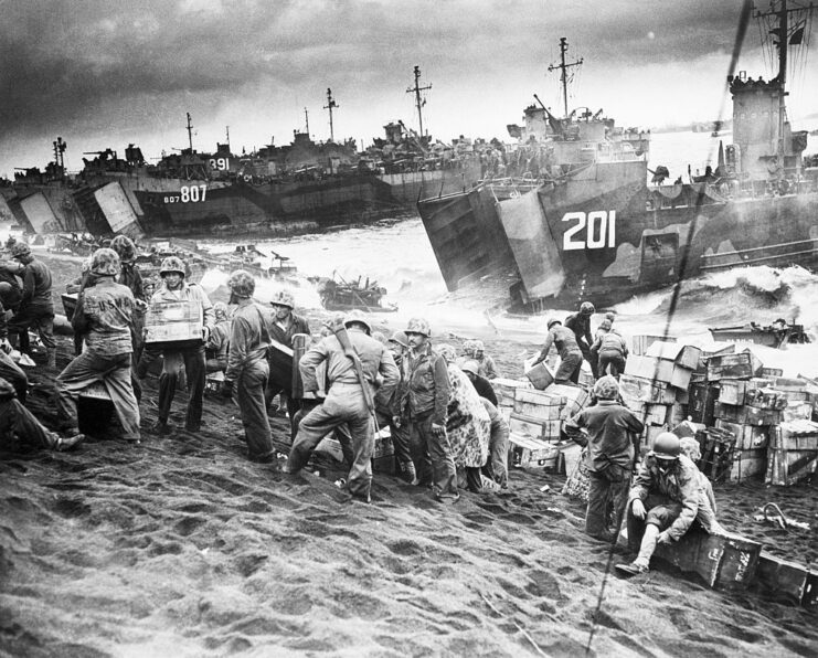 US Marines standing with crates on the shore of Iwo Jima