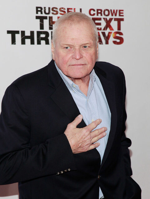 Brian Dennehy standing on a red carpet