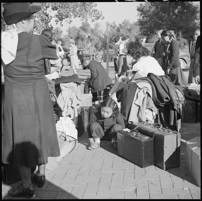 Japanese-American families standing with suitcases