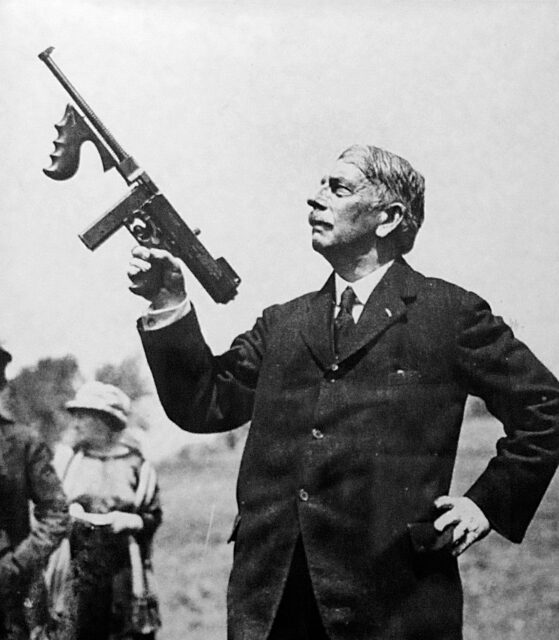 John T. Thompson holding up a Tommy Gun