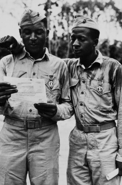Two US Marines reading a letter while standing together