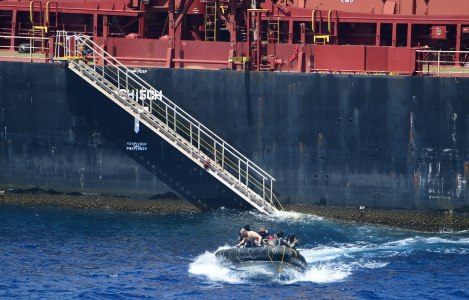 Assault boat filled with people moving away from the MV Ruen