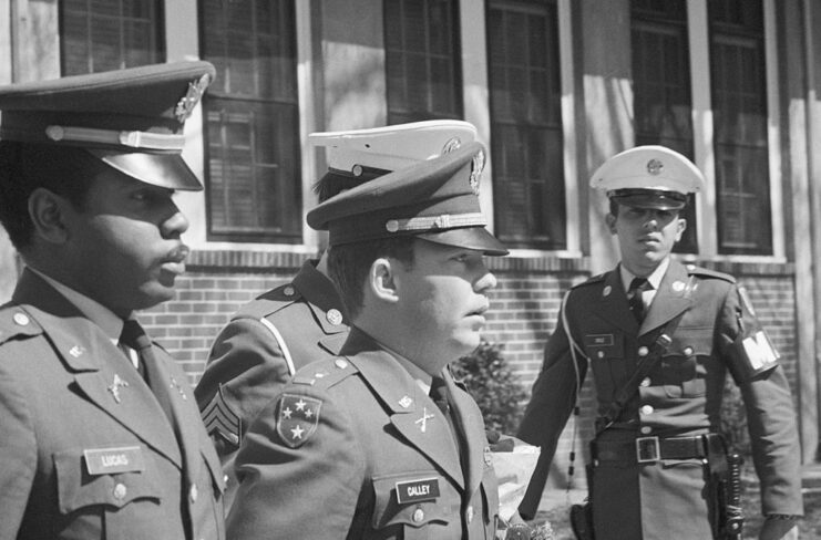 Second Lt. William Calley being led away from a building by military police
