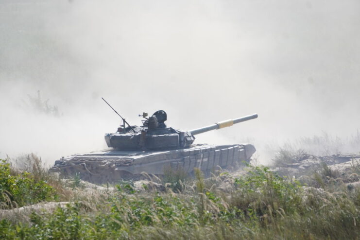 T72B3 tank driving along a dirt road