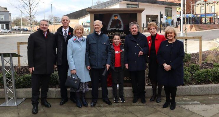 Eight individuals standing together in Thomas Brown Square