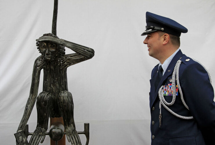 Lt. Col. Sean Cosden staring at a statue of Tojo the monkey