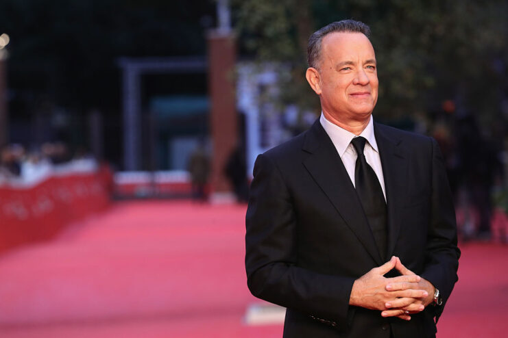 Tom Hanks standing on a red carpet