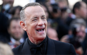 Tom Hanks standing on a red carpet