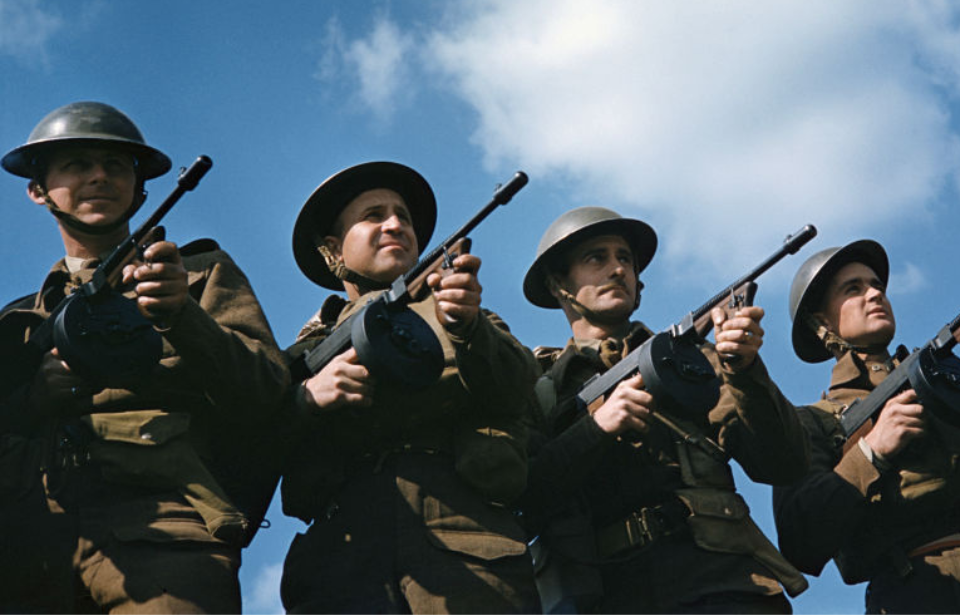 Four British infantrymen holding Tommy Guns