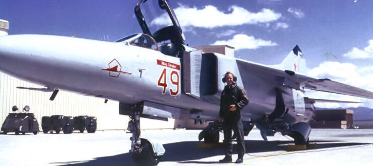 Pilot standing next to a Mikoyan-Gurevich MiG-23 on the runway