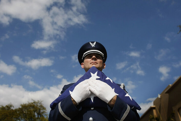 Master Sgt. Francisco Navarro holding an American flag that was folded into a triangle