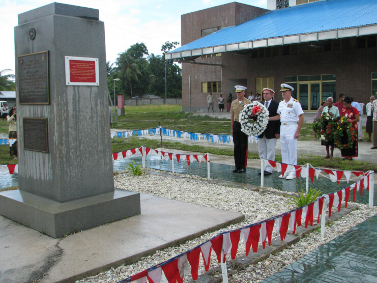 Kurt Campbell holding a wreath at the Battle of Tarawa Memorial, with Patrick Walsh and Richard Simcock standing beside him