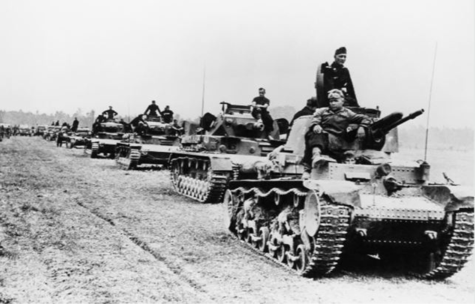 German soldiers driving tanks down a dirt road