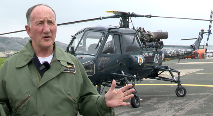 Tim de la Fosse standing in front of a Westland Wasp