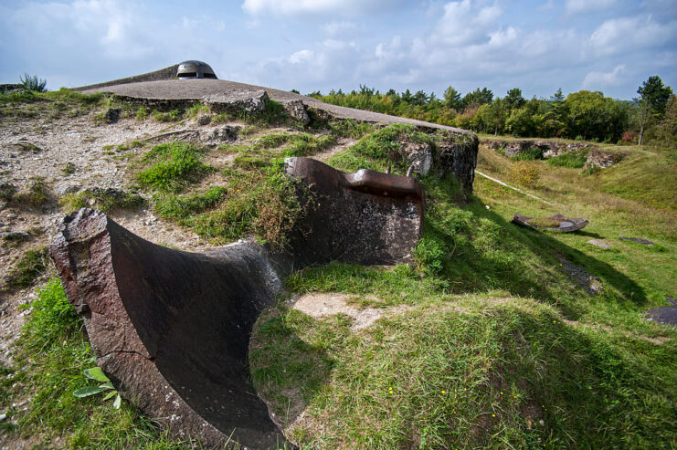 Demolished turret partially covered in grass