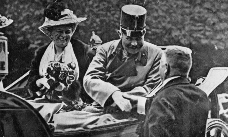 Franz Ferdinand shaking hands with a man while his wife, Sophie, watches