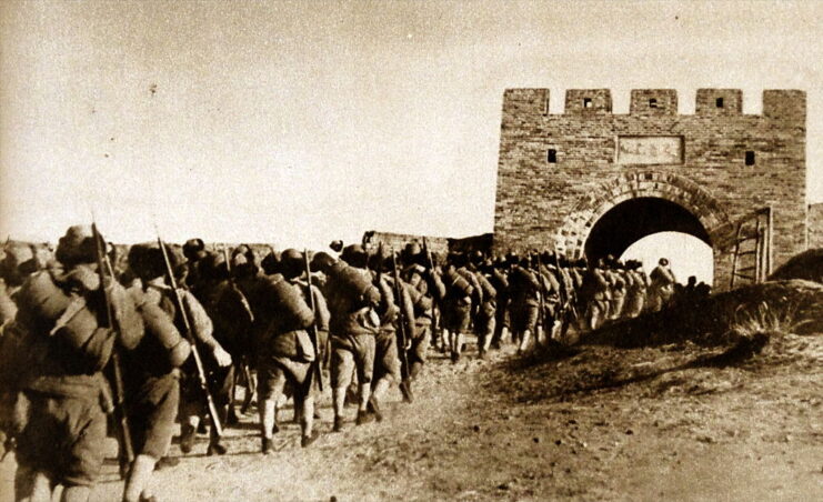 Japanese soldiers marching toward an arch