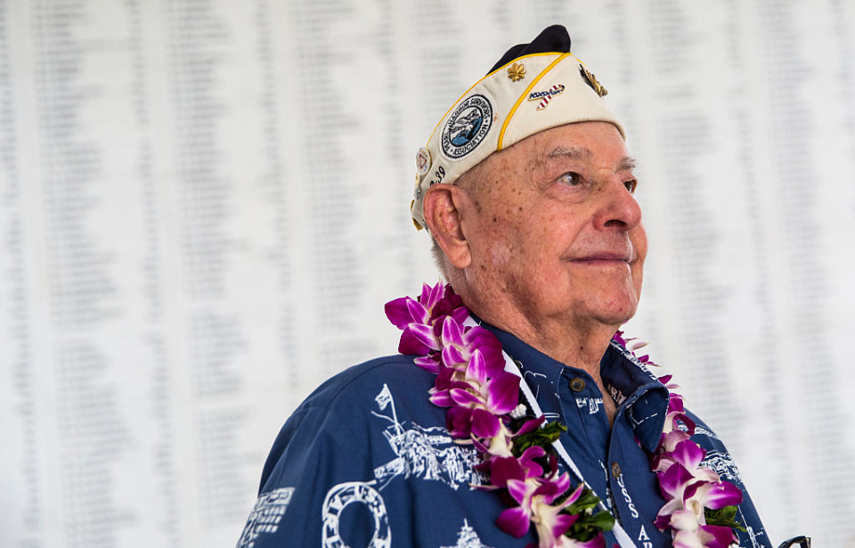 Lou Conter standing in front of the Arizona Remembrance Wall