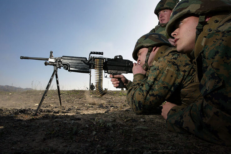 Three US Marines aiming an M249 SAW machine gun