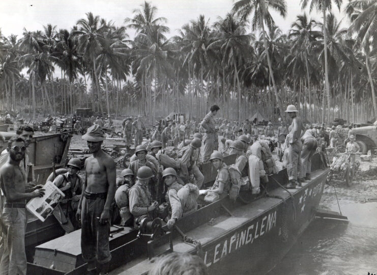 US Marines standing in and around a Higgins boat on the coast of Guadalcanal
