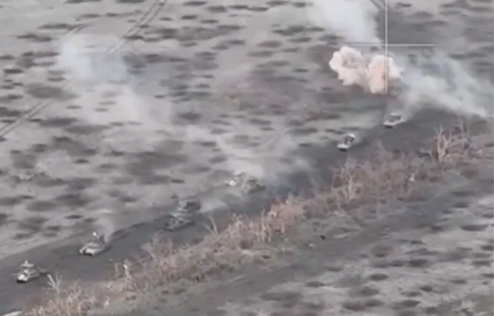 Aerial view of Russian tanks and BMPs being attacked while driving down a road