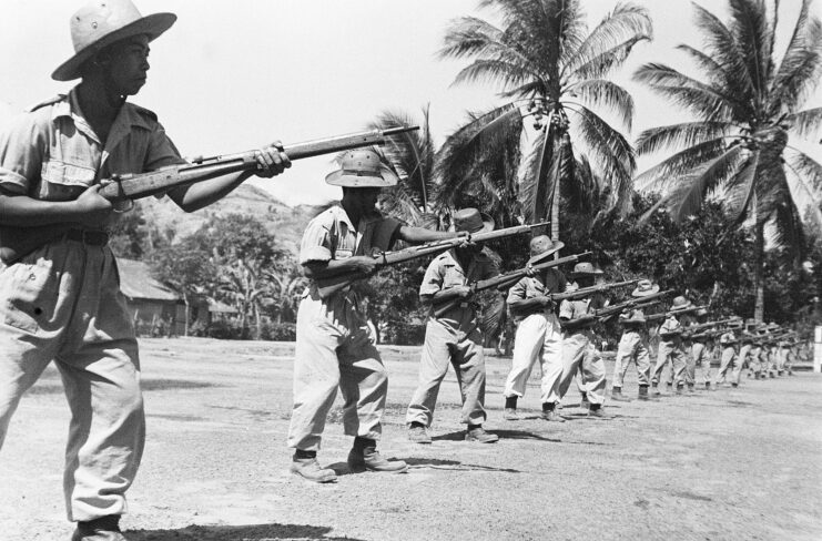 Former Indonesian National Armed Forces soldiers aiming Arisaka Type 99 rifles on a beach