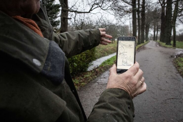 Klaas Tammes holding a smartphone with the image of a map on the screen