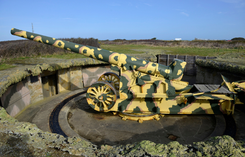 Camouflage-colored naval gun in an emplacement
