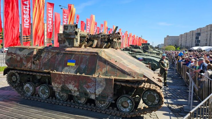 Armored vehicles and tanks lined up in a row outside