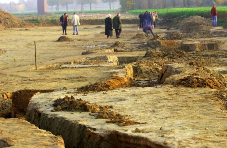 People walking around a recently-excavated World War I-era trench
