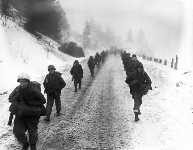 American troops marching through the snow during the Battle of the Bulge.