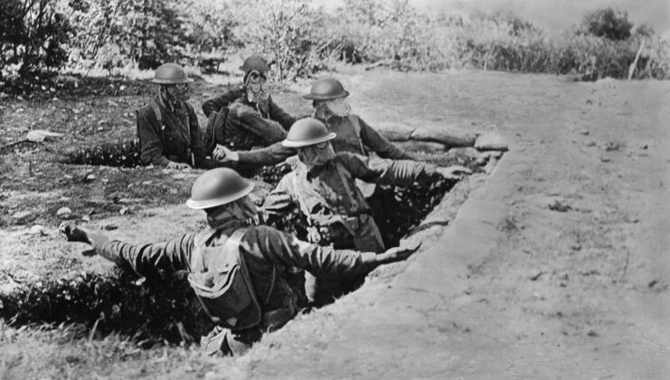Marines training in France throwing hand grenades in a trench.