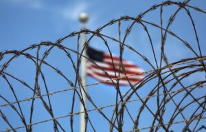 American flag behind razor wire.