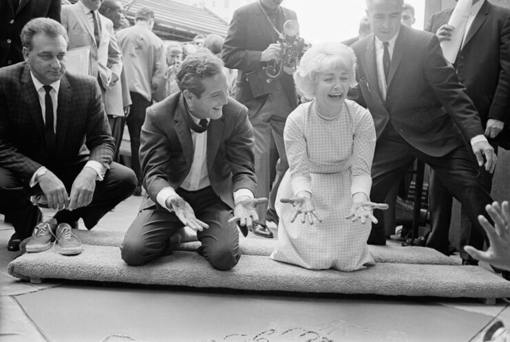 Paul Newman and Joanne Woodward putting their handprints in cement in front of Grauman's Chinese Theater.