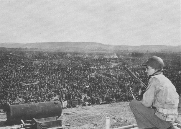 U.S. soldier taking watch over a prisoner enclosure.