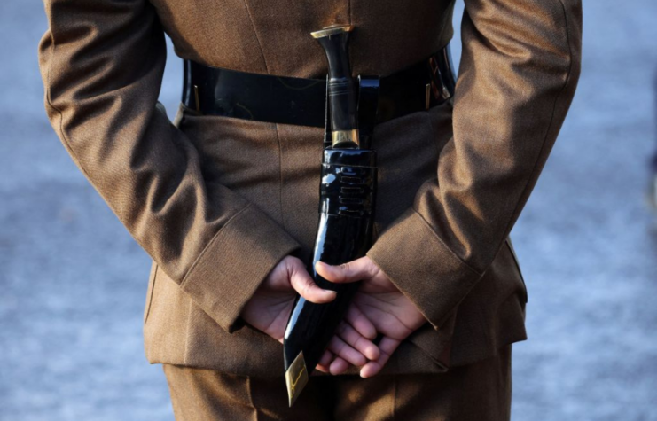 Gurkha standing with a Kukri blade behind his back