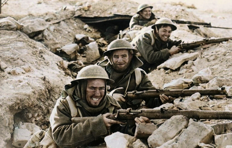 British soldiers standing in a trench, with their rifles drawn
