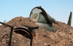 An Iraqi Air Force MiG fighter jet is buried in the sand near the Tamous air base August 2, 2003 at Habaniya, Iraq.