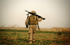 A US Marine with 1/3 Marines Weapons company carries an M240 machine gun over his shoulder during a patrol over farmland in the northeast of Marjah on February 14, 2010.