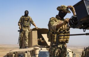 A fighter of the Syrian Democratic Forces (SDF) stands on a humvee during an exercise with forces of US-led "Combined Joint Task Force-Operation Inherent Resolve" coalition in Syria's northeastern Hasakah province on September 7, 2022.