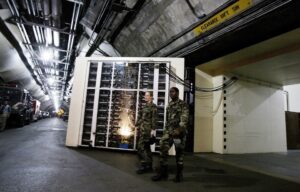 At the interior entrance to the Cheyenne Mountain Complex headquarters for NORAD two military personnel exit the administrative area.