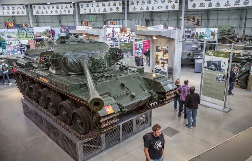 Overhead view of visitors walking around a Centurion tank on display