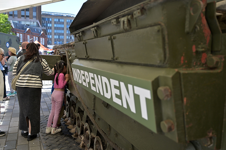 People standing next to a Churchill Mark III tank