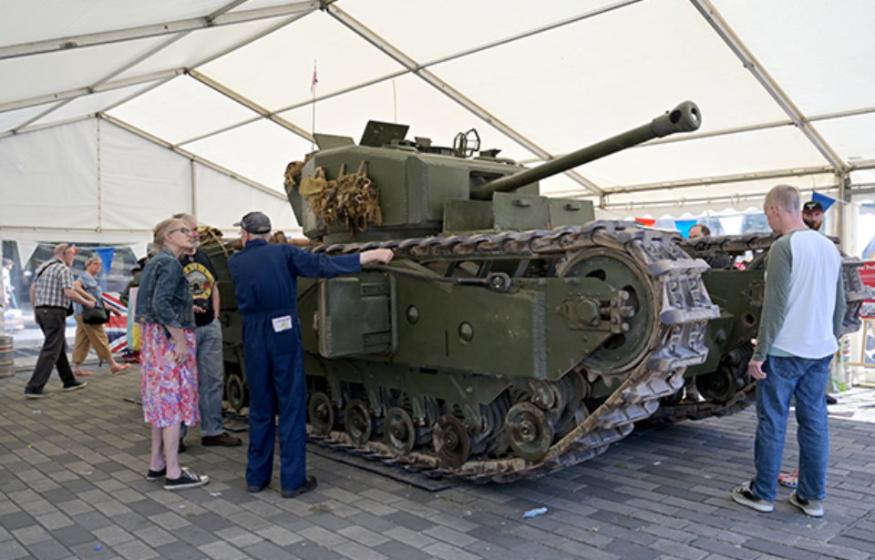 People standing around a Churchill Mark III tank